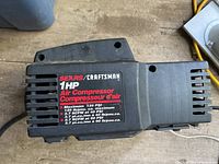 Close-up of Sears Craftsman air compressor motor label showing 1HP and maximum pressure specs