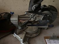 Photo of a 7 1/4 inch blade chop saw on a work surface showing the full tool including base, blade, handle, and dust bag.