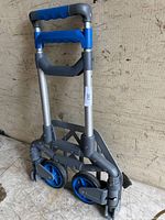 Folded dolly showing blue handles and wheels, compact and portable