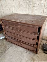 Side angle showing the steel drawer unit with four pull-out drawers closed.