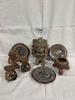 Six handcrafted Mexican clay art pieces including four figures and two round painted dishes.