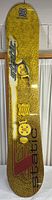 Full view of yellow textured Static snowboard with bindings attached, showing logo and design on top surface.