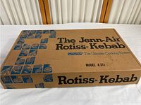 Closed cardboard box with vintage Jenn-Air Rotiss-Kebab branding, model A311.