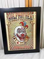 Full view of framed concert poster with the clown artwork and band name prominently visible.