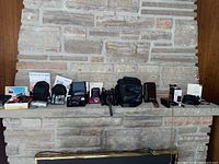 Wide view of four cameras, multiple cases, filters and accessories arranged on a stone ledge