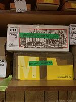 Two cardboard boxes on a wooden shelf marked 'Wood Chisel - AA 2035 1/4' with a MaxSold tag and lot number 611 visible.