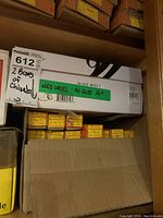 Two cardboard boxes labeled as containing wood chisels A2035 1/4 inch, stacked on wood shelving with a MaxSold tag.