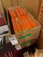 Photo showing multiple orange boxes of Matador chisels stored in a large cardboard box, with labels and lot tags visible.