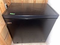 Closed black Danby Premier chest freezer showing external view with a label on top left corner.