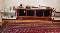 Front view of teak sideboard with four black sliding doors