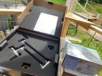 Delta Model 117 pot filler faucet in original foam packaging with parts visible and Danze faucet box beside it.