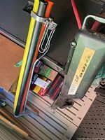 Photo of golf ball boxes including Karma, SFT, Speed Regime stacked indoors with yellow, orange, black tubes attached to metal base