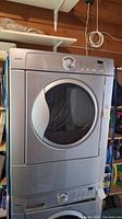 Front view of silver Kenmore dryer stacked above washer unit