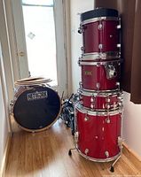 Network drum shells stacked (bass drum on left, floor tom and two rack toms with cushion on top)