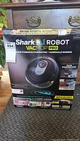 Front of packaging showing Shark AI Robot VacMop Pro with branding, model R201WD, features AI Laser Vision, sonic mopping and vacuum suction
