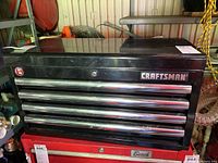 Front view of black Craftsman tool box with four drawers and chrome handles, showing the Craftsman logo on the top right.