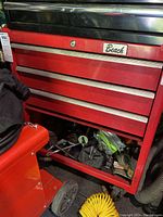 Front view showing three drawers with lower drawer open and contents visible