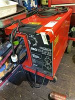 Full view of red Silver Beauty MIG Welder on cart with cables coiled on top
