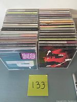 Front view of two stacks of CDs with visible spines and covers showing band names and album titles