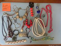 Photo showing all jewelry laid out on surface including necklaces, rings, brooch, and hair combs, viewed from above.