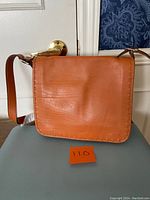 Front view of the brown leather satchel messenger bag showing smooth leather and flap closure.