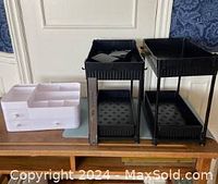 Photo showing two black two-tier organizers and one white drawer organizer on a wooden surface.