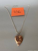 Full view of necklace with silver stamped chain and heart-shaped stone pendant.