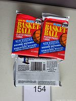 Photo showing three sealed jumbo packs of 1991-92 Fleer Basketball Player Photo Cards. Two packs are positioned upright showing front design, one pack shows back with barcode and card count (48 cards).