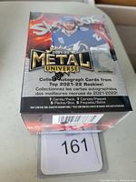 Sealed blaster box of 2021-22 Skybox Metal Universe hockey cards with colorful packaging showing a player and product information.