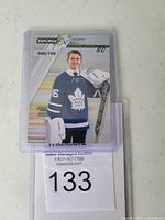 Front view of Joseph Woll Synergy FX rookie hockey card numbered 046 out of 749, showing player in goalie uniform.