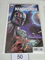 Front cover of Star Wars The Mandalorian #3 variant comic book showing The Mandalorian and Grogu in a spaceship with a space background.