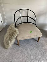 Front angle showing the chair with upholstered seat, metal back, wooden spindle legs, and faux fur pillow on the seat.