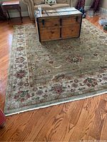 Full view of rug under wooden chest and sofa