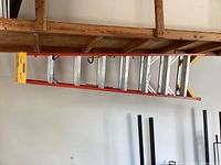 Side view of the full 8-foot Werner ladder showing metal rungs with orange bracing and yellow plastic end caps.