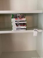 Stack of Xbox One game cases showing multiple titles including Call of Duty and NBA games.
