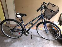 Side view of blue Solaris 18 speed supercycle bicycle with front basket and pedal visible.