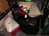 Photo showing Coleman cooler, red lantern, Swiss Gear tent bag and beverage containers on storage shelf.