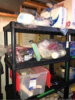 Photo of plastic shelving with disposable plates, straws, napkins, and plastic flatware in bulk packaging.