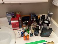 Overview of ten cologne and deodorant items on counter