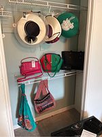 Shelf with five women's hats and five purses arranged on and hanging from wire shelf