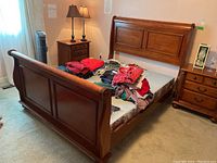 Three-quarter view of assembled bed frame showing headboard, footboard and side rails