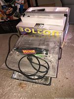 Full view of Bolton tile/marble saw with original box and packaging pieces in background.