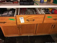 Wooden drawers with various tools and hardware inside, showing organization and storage of lot items.