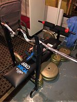 Full view of York weight bench with curl bar racked and several weight plates nearby