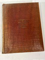 Front cover showing brown textured leather with gold embossed text.