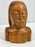Front view of carved wood bust showing the smooth polished finish and facial details.