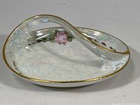 Front side view of the vintage MZ Altrohlau porcelain dish with curved handle, showing gold rim and pink floral hand-painted design on iridescent glaze.