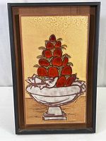 Full view of the framed terracotta glazed tile artwork showing the red fruit pyramid and bird in pedestal bowl.