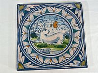 Front view of large hand painted terracotta tile showing rabbit in garden scene with decorative border and crackle finish.