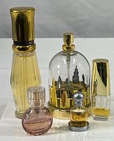 Photo showing all five partial perfume and cologne bottles together, highlighting the size and style variety.